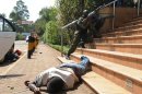 Armed policemen try to get entry after masked gunmen stormed an upmarket mall on September 21, 2013 in Nairobi