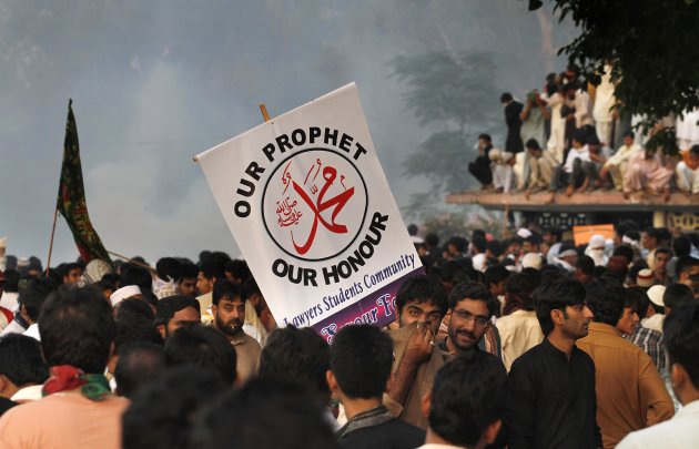 Pakistani protestors gather as police fire tear gas to disperse them during clashes that erupted as protestors tried to approach the U.S. embassy, Friday, Sept. 21, 2012 in Islamabad, Pakistan. Protests by tens of thousands of Pakistanis infuriated by an anti-Islam film descended into deadly violence on Friday, with police firing tear gas and live ammunition in an attempt to subdue rioters who hurled rocks and set fire to buildings in some cities. Four people were killed and dozens injured on a holiday declared by Pakistan's government so people could rally against the video. (AP Photo/Anjum Naveed)