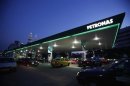 Motorists queue to fill natural gas at a Petronas station with its landmark Petronas Twin Towers headquarters in the background, in Kuala Lumpur
