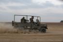 Israeli soldiers ride a military vehicle outside the northern Gaza Strip