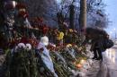A woman places flowers at the site of an explosion on a trolleybus in Volgograd