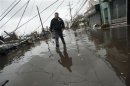 A man walks through floodwaters in the Rockaways section of New York