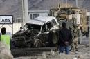 U.S. troops remove a damaged vehicle, which was hit by a suicide attack, in Kabul