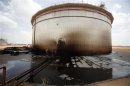 Sudanese engineers check the damage to an oil tank at a largely damaged oilfield in Heglig
