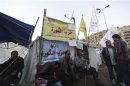 Protesters against Egypt's President Mursi rest in front of a tent named "Revolution Party" at Tahrir Square in Cairo