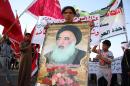 An Iraqi man holds a placard bearing a portrait of Shiite Muslim spiritual leader Grand Ayatollah Ali al-Sistani