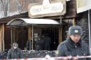 Police officers stand in front of the entrance of the Lame Horse nightclub where a fire took place in the centre of Perm