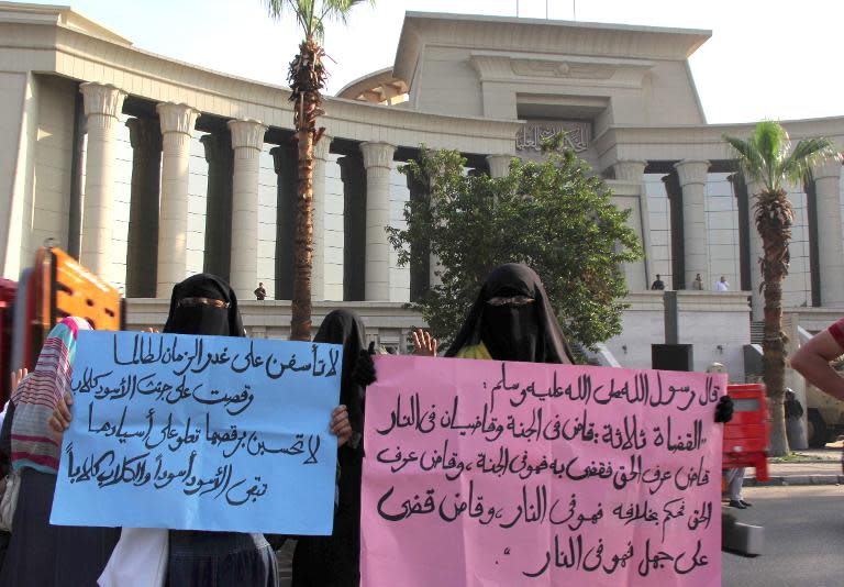 Veiled women supporters of Mohammed Morsi hold up signs with Islamic texts as they rally outside the High Court in Cairo, on November 4, 2013