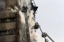 Iranian firefighters work to extinguish a fire at the Plasco building in central Tehran. (AP)
