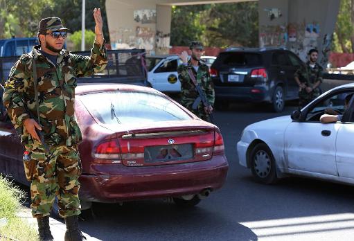 Libyan military personnel man a checkpoint set up to try to secure the capital, Tripoli, on October 20, 2013