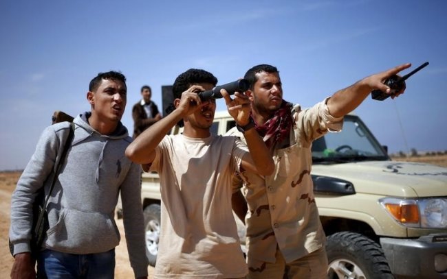 Libya Dawn fighters look at Islamic State militant positions near Sirte March 19, 2015. The Libya Dawn armed group backs the self-declared government ...