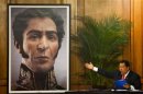 Venezuelan President Chavez shows an image of independence hero Bolivar during a ceremony in Caracas