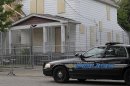 A Cleveland police patrol car sits in front of the boarded up home of Ariel Castro in Cleveland Tuesday, May 14, 2013. Three women were rescued from the house last week after a decade in captivity. Castro is under arrest and charged with rape and kidnapping. (AP Photo/Mark Duncan)