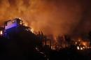 An out of control forest fire destroys homes in the city of Valparaiso, Chile, Sunday April 13, 2014. Authorities say the forest fire has destroyed at least 150 homes and is forcing evacuations. ( AP Photo/ Luis Hidalgo)