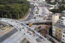 Rescue workers try to reach vehicles trapped underneath a bridge that collapsed while under construction in Belo Horizonte
