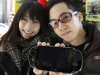 A couple show off their newly purchased PlayStation Vita portable game in Shibuya shopping district in Tokyo Saturday, Dec. 17, 2011. Sony's long-waited PS Vita hit stores in Japan on Saturday, with the company predicting brisk sales even though the launch has missed much of the holiday shopping season. (AP Photo/Kyodo News) JAPAN OUT, MANDATORY CREDIT, NO LICENSING IN CHINA, FRANCE, HONG KONG, JAPAN AND SOUTH KOREA