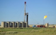 <p>Natural gas is burned off next to an oil well being drilled at a site August 23, 2011 near Tioga, North Dakota in the United States.</p>