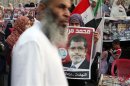 A supporter holds a poster of Egypt's President Mursi at Tahrir square in Cairo