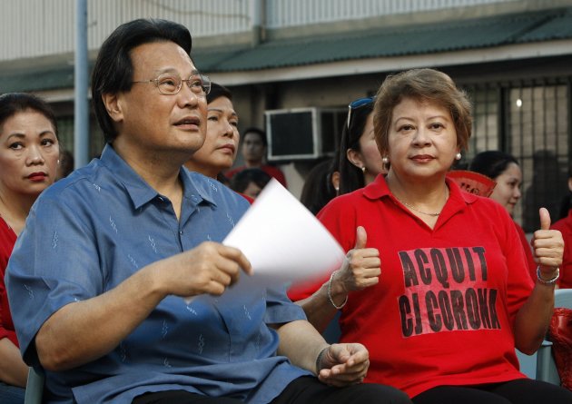 Supreme Court Chief Justice Renato Corona (L) sits next to his wife Cristina, wearing T-shirts bearing the message "Acquit CJ Corona", during a mass inside a Supreme Court hall in Manila May 17, 2012. Corona will testify in his Senate impeachment trial on Tuesday after he was accused of failing to disclose several bank accounts containing millions of pesos, and real estate properties in his Statement of Assets, Liabilities and Net worth (SALNs), local media reported. REUTERS/Romeo Ranoco (PHILIPPINES - Tags: POLITICS CRIME LAW)