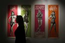 A worker walks past a complete set of original cinema door panel posters from the film "Thunderball", during a media preview of "50 Years of James Bond - the Auction", at Christie's in London