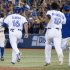 Toronto Blue Jays' Rajai Davis, left, turns to celebrate with on rushing teammates after hitting a game-winning single during the ninth inning against Baltimore Orioles baseball game in Toronto on Friday June 21, 2013. (AP Photo/The Canadian Press, Chris Young)