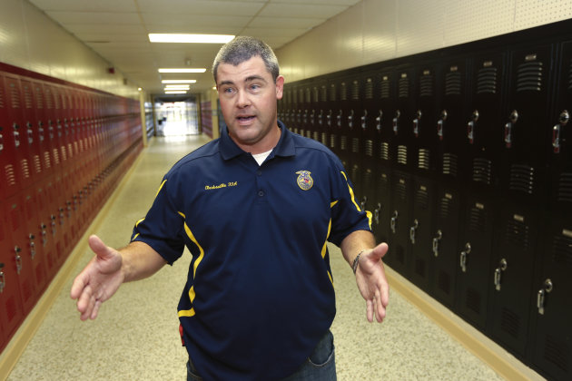 In this photo taken July 11, 2013, Cheyne Dougan, assistant principal at Clarksville High School, is interviewed at the school in Clarksville, Ark. Dougan is one of 20 Clarksville School District staff members are training to be armed security guards on campus. (AP Photo/Danny Johnston)