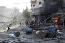 Residents run after, according to activists, two barrel bombs were thrown by forces loyal to Syria's president Al-Assad in Aleppo