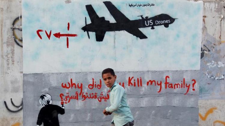 A Yemeni boy walks past a mural depicting a US drone and reading " Why did you kill my family" on December 13, 2013 in the capital SanaaEMEN-UNREST-DRONE