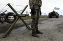 A Ukrainian soldier and armored personnel carrier guard a checkpoint near the village of Salkovo