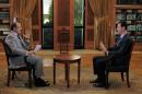 A handout picture released by the official Syrian Arab News Agency (SANA) on October 21, 2013 shows President Bashar al-Assad (R) giving an interview to a journalist of the Lebanese channel al-Mayadee, in Damascus