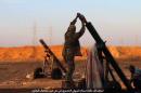 In this image posted on Thursday, Oct. 8, 2015, by the Rased News Network, a Facebook page affiliated with Islamic State, shows Islamic State militants preparing to fire a mortar to shell towards Syrian government forces positions at Tal Arn in Aleppo province, Syria. Islamic State militants seized several villages from rival insurgents north of Aleppo city Friday, in a surprise attack that came despite intensive Russian airstrikes that Moscow insists are targeting the extremist group, activists said. Arabic reads, "Targeting positions of the Alawite army in Tal Arn with mortar shells." (Islamic State militant website via AP)