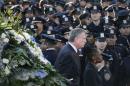 New York Mayor de Blasio and wife Chirlane walk past a sea of policemen while arriving for the funeral services of NYPD officer Ramos in the Queens borough of New York