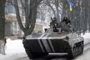 Members of the Ukrainian armed forces drive an armored vehicle in the town of Volnovakha