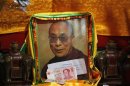 Chinese bank notes from faithful are placed in front of a portrait of Tibetan spiritual leader Dalai Lama at Kumbum monastery on the outskirts of Xining