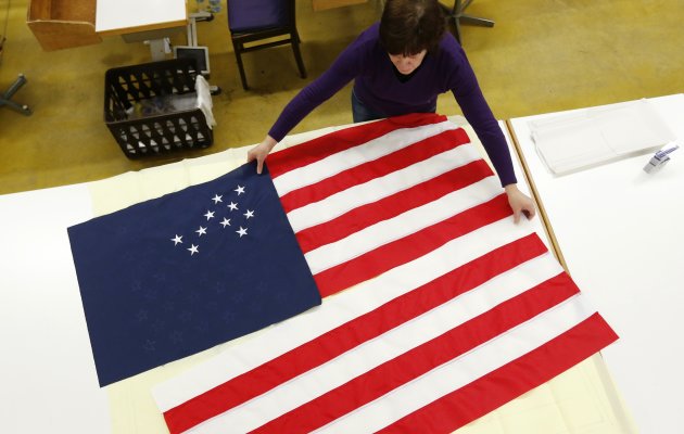 A worker adjusts pieces of a U.S. national flag at the Waelkens flag company in Oostrozebeke February 4, 2013. When U.S. President Barack Obama was sworn in for his second term on January 21, it's a decent bet that one of the flags fluttering behind him on the U.S. Capitol was made in Belgium. The Waelkens flag company, based in the small town of Oostrozebeke in Flanders, supplies around 2,000 flags a year to the United States, with clients including the Pentagon and other U.S. government departments as well as the United Nations. Picture taken February 4, 2013.  REUTERS/Francois Lenoir (BELGIUM - Tags: POLITICS BUSINESS)
