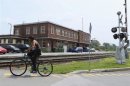 A cyclist rides past the building of the Maine, Montreal and Atlantic Railways (MMA), whose oil-tanker exploded last Saturday, in the town of Farnham, Quebec