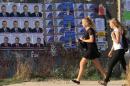 Girls walk past election campaign posters of candidates running for deputies ahead of September 18 parliamentary elections in Sevastopol