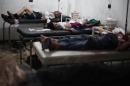 Victims lie on beds as they are treated at a makeshift hospital following reported shelling by Syrian government forces on Douma, northeast of the capital Damascus, on July 30, 2014