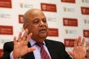South African finance minister Pravin Gordhan gestures in his office in Pretoria, as he speaks via video link to a Thomson Reuters investment conference in Cape Town South Africa