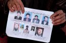 A missing-persons poster, with pictures of nine men who their relatives say were last seen being arrested by U.S. special operations forces, is held by a villager in Maidan Shahr, Afghanistan on Sunday, March 10, 2013. The posters were up for several months, but taken down after the bodies were found buried in a field near a U.S. base in Narkh district, about 15 kilometers (about 10 miles) from Maidan Shahr, capital of the Wardak province. An Afghan who once translated for the U.S. Special Forces was arrested on allegations of widespread torture and murder in connection with the disappearance and deaths of at least nine Afghans, the Afghan intelligence confirmed Monday, July 8, 2013. (AP Photo/Anja Niedringhaus)