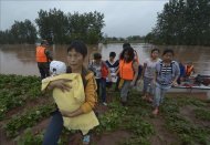 Evacuados por las inundaciones del pueblo de Chuangliu llegando de manera segura al condado de Rongchang, en la municipalidad de Chooging, al suroeste de China. EFE
