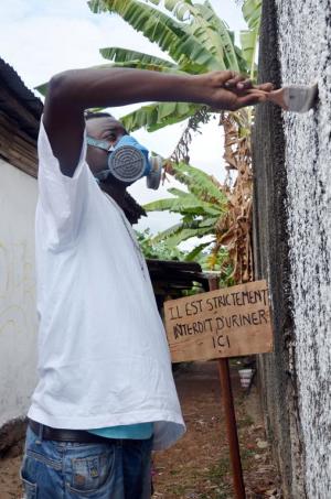 Gabonese artist Blatino paints a graffiti design near …