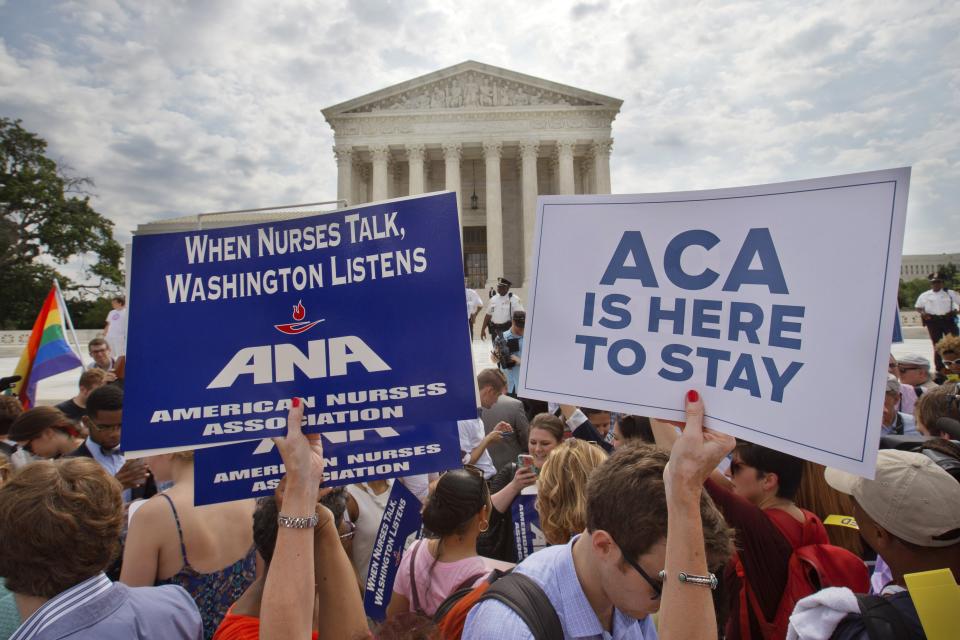 FILE - In this June 25, 2015, file photo, supporters of the Affordable Care Act hold up signs as the opinion for health care is reported outside of...