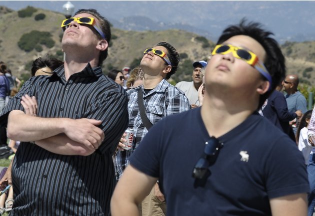 People wearing eclipse glasses …