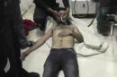 In this Friday, April 11, 2014 image made from amateur video, provided by Shams News Network, a loosely organized anti-Assad group based in and out of Syria that claim not to have any connection to Syrian opposition parties or any other states, and is consistent with independent AP reporting, shows a man as he lies on the floor with an oxygen mask at a hospital room in Kfar Zeita, some 200 kilometers (125 miles) north of Damascus, Syria. Syrian government media and rebel forces said Saturday, April 12, 2014 that poison gas had been used in the village, on Friday injuring scores of people, while blaming each other for the attack. (AP Photo/Shams News Network)