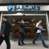People walk past a branch of Barclays Bank in the City of London