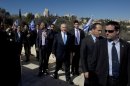 Israeli Prime Minister Benjamin Netanyahu, center, is surrounded by bodyguards as he arrives with Jerusalem Mayor Nir Barkat, second right, and Likud party member Moshe Kahlon, left, to brief the media in Jerusalem, Monday, Jan. 21, 2013. General elections in Israel will be held Tuesday, Jan. 22, 2013. (AP Photo/Sebastian Scheiner)