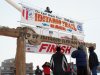 Volunteers hang a banner above the burled arch, which serves as the finish line for the 1,000-mile Iditarod Trail Sled Dog Race in Nome, Alaska, on Monday, March 11, 2013. The race began March 3 in Willow, Alaska, and some race watchers predict a Tuesday finish. (AP Photo/Mark Thiessen)