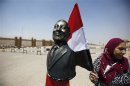A supporter of Egypt's former President Mubarak stands next to a bust of Mubarak outside a police academy before Mubarak's trial in Cairo