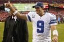 Dallas Cowboys quarterback Tony Romo flashes a thumbs-up as he walks off the field after the Cowboys defeated the Washington Redsksins 24-23 in an NFL football game in Landover, Md., Sunday, Dec. 22, 2013. (AP Photo/Evan Vucci)